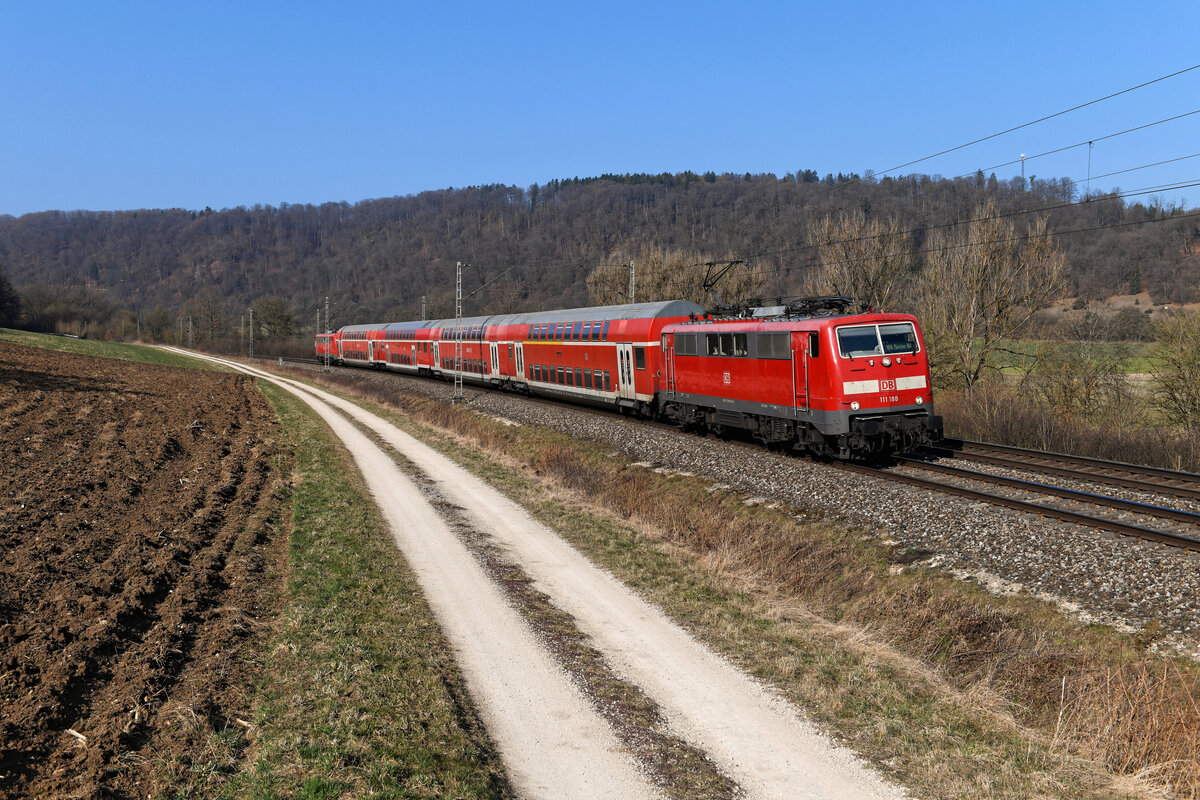 Als Twindexx-Ersatz verkehrte die RB 59089 am 26. März 2022 mit einer Doppelstockwagen-Garnitur und zwei 111-ern in Sandwich-Bespannung. Es führte die 111 188, die einst ihre Karriere als S-Bahn Lok an Rhein und Ruhr begann. Bei Obereichstätt konnte ich den Einsatz dokumentieren. Zu Planzeiten des lokbespannten Reisezugverkehrs im Altmühltal wäre der Zug nur  Steuerwagen voraus  umzusetzen gewesen.