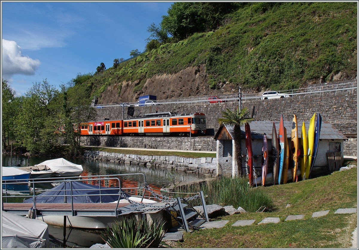 Als Variante ohne Gegenlicht (siehe http://www.bahnbilder.de/bild/schweiz~privatbahnen~flp-ferrovie-lugano-ponte-tresa/782994/diskret-im-hintergrund-aber-sehr-zum.html ): Bei Agno fährt ein FLP Regionlazug am Bootshaus mit den bunten Kanus vorbei. 
30. April 2015