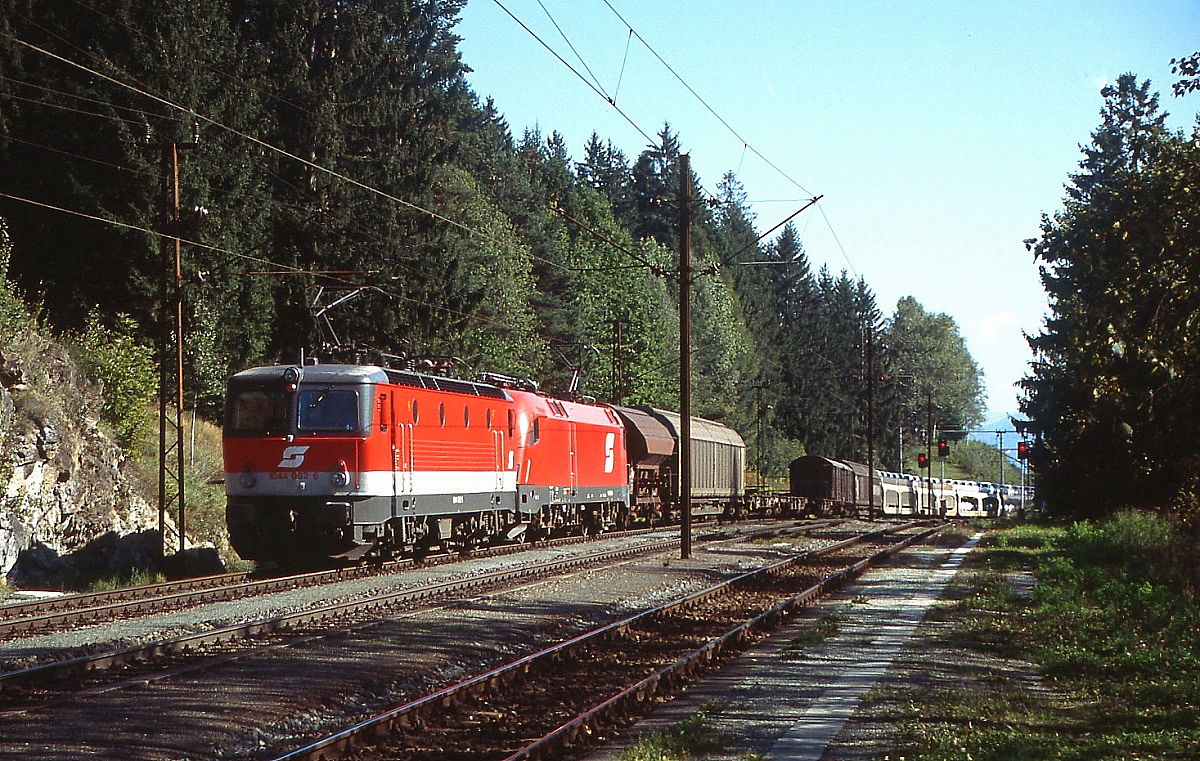 Als Vorspannlok vor einem Taurus fährt 1044 062-5 im September 2003 in den Bahnhof Mühldorf-Möllbrücke ein. Zu diesem Zeitpunkt war der Bahnhof noch nicht umgebaut und die Fahrleitungsmasten aus der Anfangszeit der Elektrifizierung standen noch.