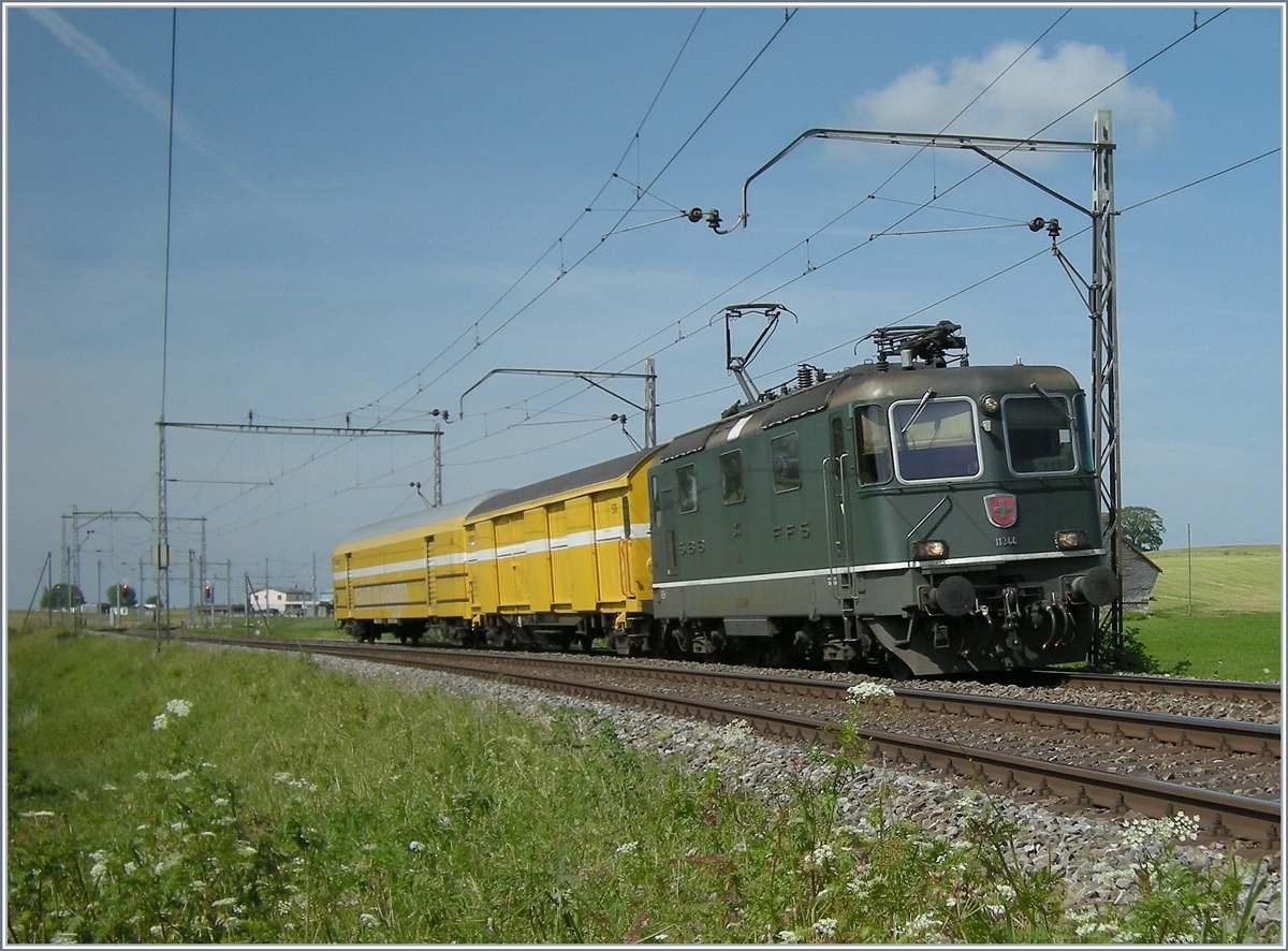 Als zwischen Cottens und Neyruz auf der Strecke Lausanne - Bern noch diese alten Fahrleitungsmasten standen, war die grüne SBB Re 4/4 II 11344 mit einem Postzug kurz nach Cottens in Richtung Fribourg unterwegs. 

19. Juni 2008