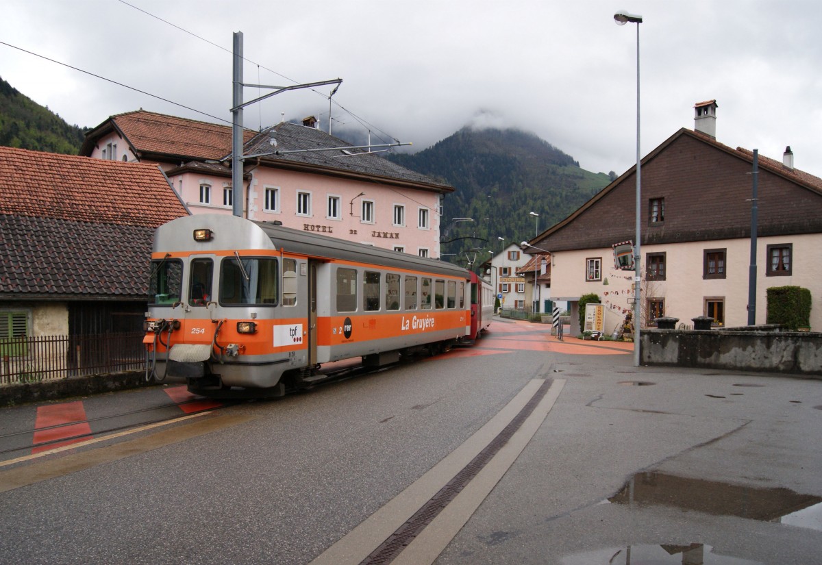 Am 02.05.2014 fährt ein Zug der Transports publics fribourgeois, bestehend aus Bt254, einem weiteren Bt und BDe 4/4 141 die Ortsdurchfahrt von Montbovon.