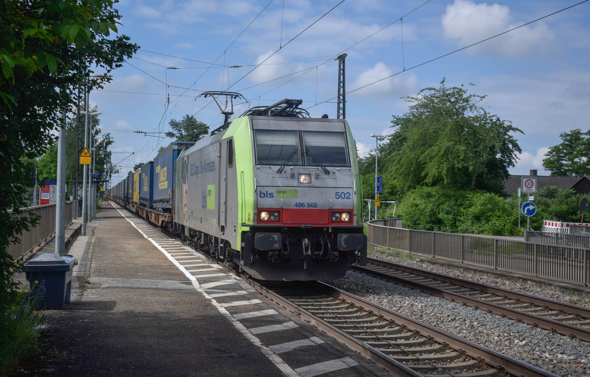 Am 02.06.2018 durchfährt die 486 502 mit einem langen Trailerzug den Haltepunkt Buggingen dem Ziel Zeebrugge entgegen.