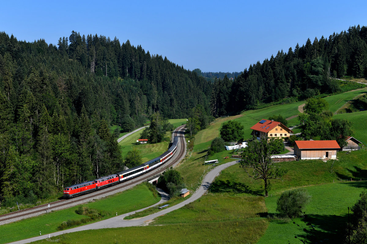 Am 04. August 2018 brachten die 218 430 und 422 den EC 191 von Lindau nach München HBF. Baustellenbedingt wurde über Kempten umgeleitet. So konnten die Reisenden die Fahrt über die landschaftlich reizvollere Allgäubahn genießen. Bei Weißenbahmühle schlängelt sich die Strecke durch ein enges Tal und führt an einem für diese Region typischen Gehöft vorbei.