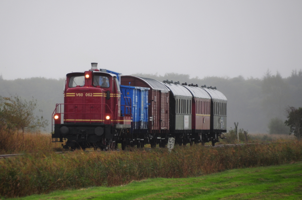 Am 05.10.2014 befuhr gegen 11.00 Uhr bei mäßigem Wetter (Nieselregen) der Museumszug mit V60 062 der  Küstenbahn Ostfriesland e.V.  als Vorspann die Strecke zwischen Hage und Westerende in Richtung Dornum.