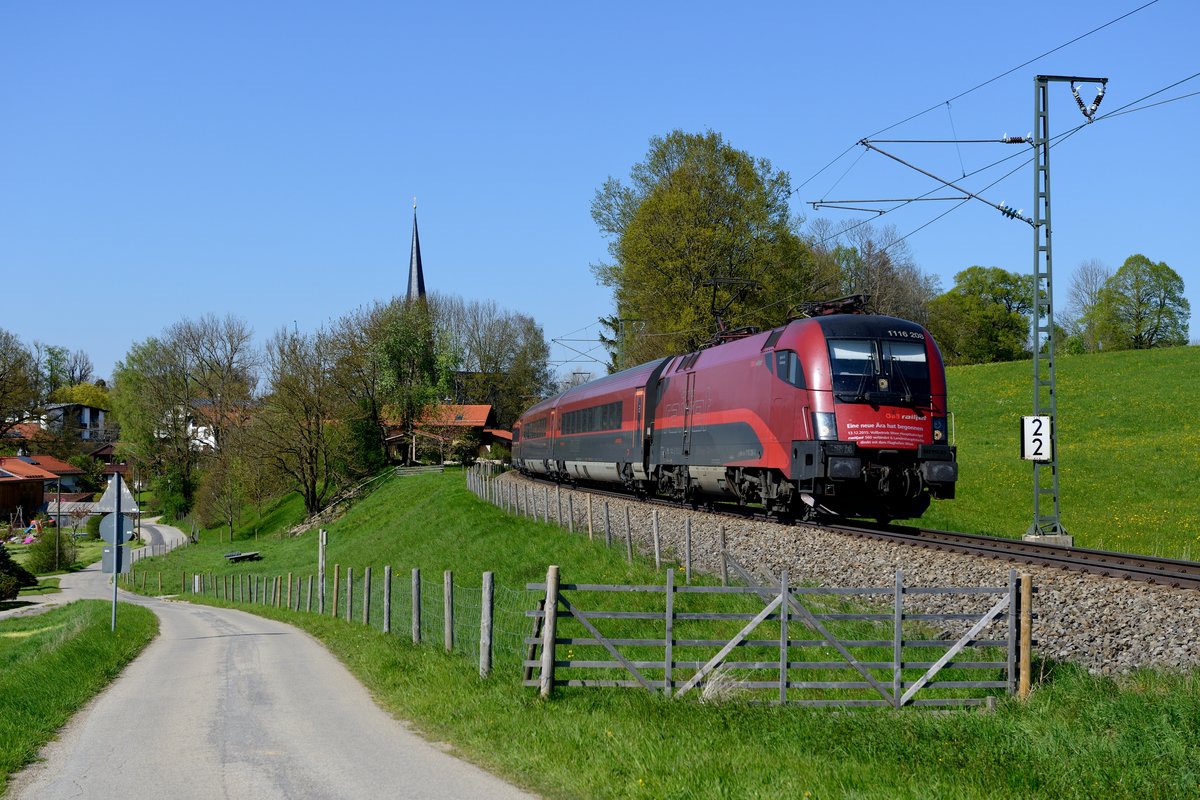 Am 06. Mai 2016 war die KBS 950 aufgrund von Bauarbeiten komplett gesperrt. Daher nahmen die meisten Züge - sofern sie nicht ausgelegt waren - zwischen Rosenheim und München den Weg über die Mangfalltalbahn. So auch der RJ 62 von Budapest-Keleti, der an diesem Tag von der 1116.208 geführt wurde. Diese Lok trägt an der Stirnfront eine Aufschrift, die an die Eröffnung des neuen Wiener Hauptbahnhofs im Dezember 2015 erinnert. Aufgenommen wurde der Fernzug bei Föching.