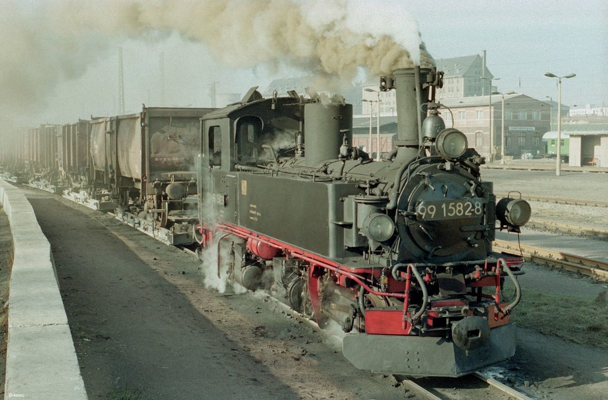 Am 06.02.1990 wartet die Lok  »99_1582-8«  [Hartmann 3592 / Bj.1912]  in Oschatz auf den Abfahrauftrag, um ihren Güterzug in Richtung Mügeln zu befördern.