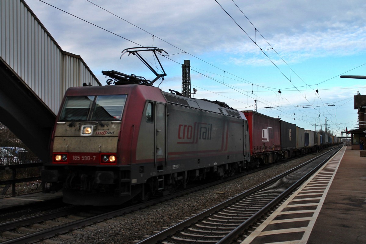 Am 06.02.2014 die Beacon Rail/Crossrail 185 590-7 mit einem typischen Crossrail-Containerzug aus Belgien, der sein Ziel in Italien hat. Hier ist der Zug bei der Durchfahrt im Bahnhof von Orschwier mit Wolkenhimmel gen Süden. 
