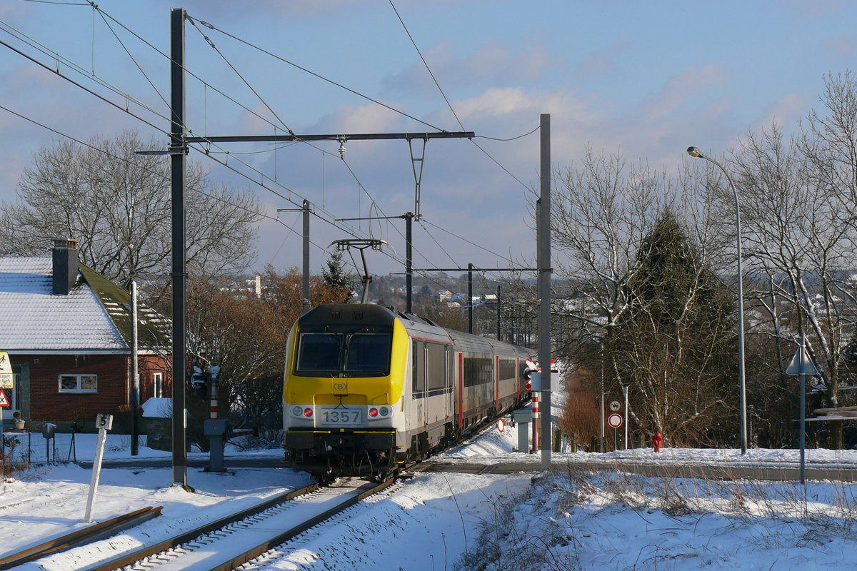 Am 06/03/2010 war Eupen noch von einer geschlossenen Schneedecke überzogen. Die SNCB-Lok 1357 schiebt den ICa Oostende - Eupen auf dem letzten abschüssigen Stück dem Bahnhof Eupen entgegen hier, aufgenommen am BÜ Buschbergerweg.