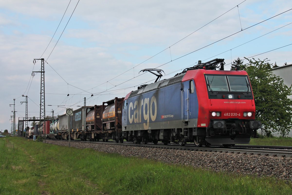 Am 06.05.2019 bespannte Re 482 030-4 einen langen Containerzug nach Italien, als sie durch den Haltepunkt von Auggen über die Rheintalbahn in Richtung Schweizer Grenze fuhr.