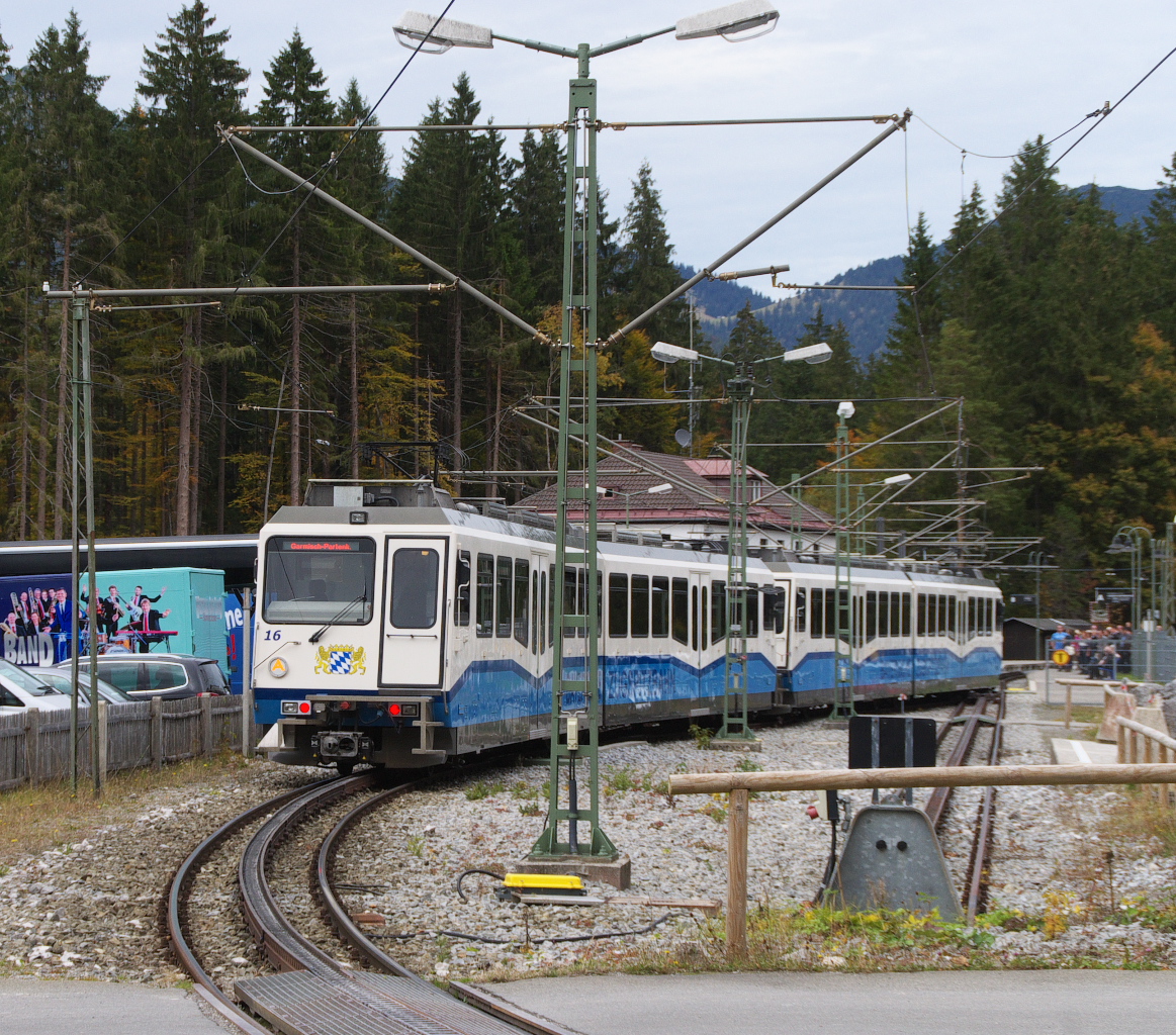 Am 06.10.2015 machten wir eine Wanderung um den Eibsee am Fuße der Zugspitze. Nach der Umrundung des Sees ging es noch kurz zur Zugspitzbahn. Triebwagen 15 + 16 sind talwärts auf dem Weg nach Garmisch-Partenkirchen, hier kurz vor der Einfahrt zum Bahnhof Eibsee auf etwas mehr als 1000 Meter Höhe. Viele Fahrgäste warten auf den Zug in Richtung Garmisch. Bahnstrecke 9540 Garmisch-Partenkirchen - Zugspitzplatt.