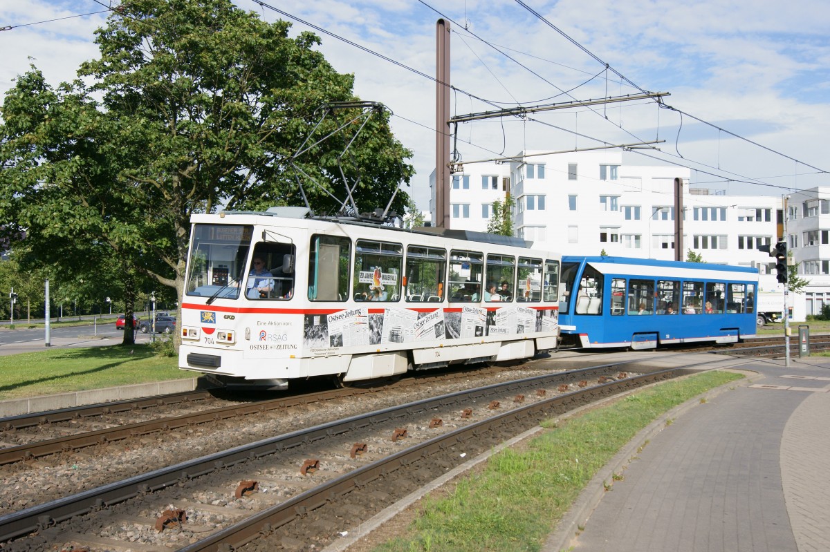 Am 07.07.2014 durchführt T6A2 Nr. 704 mit unbekanntem NB4 der Rostocker Straßenbahn AG die Kurve vor Lütten Klein Zentrum in Richtung Rügener Straße. 
