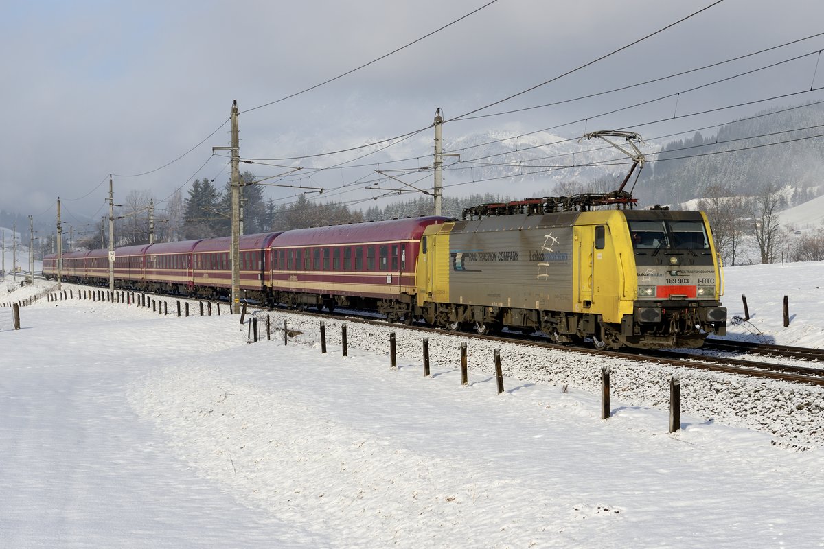 Am 08. Februar 2014 löste sich die Bewölkung nur sehr zögerlich auf, der Wilde Kaiser im Bildhintergrund ließ sich nur erahnen, als die Lokomotion 189 903 mit dem Schnee-Express D 13189 die Fotostelle bei Fieberbrunn passierte. Dieser private Turnuszug verkehrt nun schon seit einigen Jahren während der Wintersaison und startet am Freitagnachmittag in Hamburg und fährt durch das Ruhrgebiet über Köln nach Tirol und ins Salzburger Land.