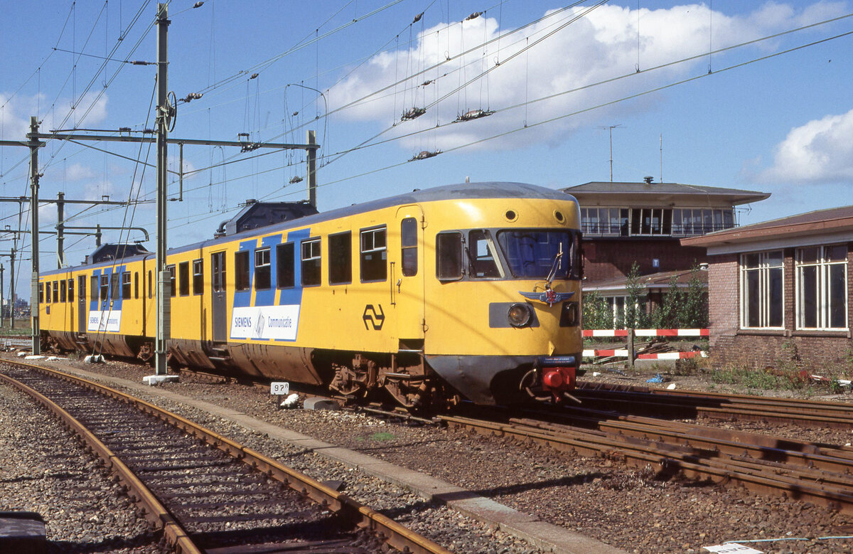 Am 08.09.1990 gab es eine Bereisungsfahrt mit NS 165, u a zum Bahnhof Watergraafsmeer (Betriebsbahnhof in Amsterdam). Der Zug wartet auf Abfahrt neben den Zentralstellwerk. Für die Fotografen wurde der Allan-Flügel provisorisch an der Fahrzeugfront angehängt. Scanbild 98250, Kodak Ektachrome 100HC.