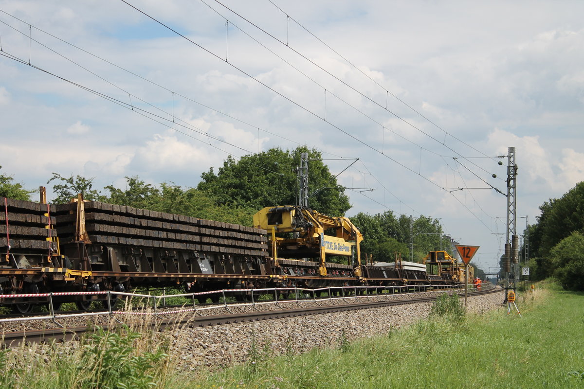 Am 09. Juli 2016 steht der Spitzke Gleisbauzug auf der KBS 990 zwischen Adelschlag und Tauberfeld. Hier zu sehen die alten Schwellen und der fahrbare Kran für die neuen Beton und die alten Holzschwellen. Im Hintergrund werden die Schwellen getauscht und das neue Gleis eingefädelt.