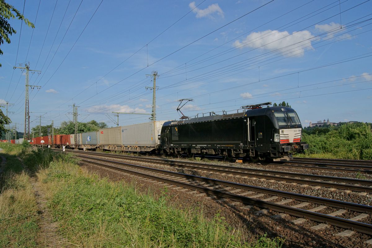 Am 09.07.2016 fährt X4E 870 mit einem Containerzug vor der Kulisse der Festung Marienberg in den Bahnhof Würzburg Zell ein. Vermutlich handelt es sich um Zug 69168 auf dem Weg von Nürnberg nach Hamburg-Altenwerder.