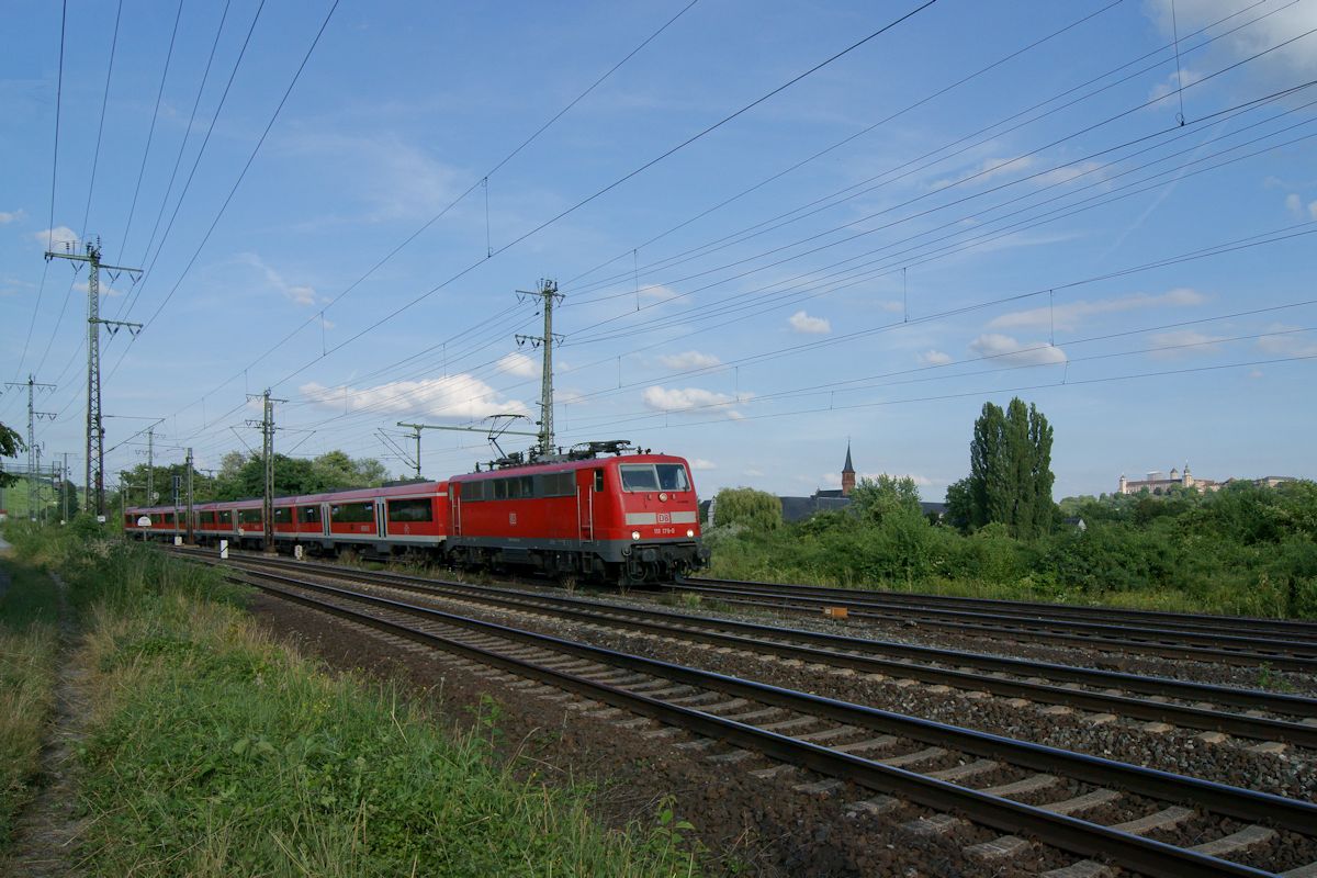 Am 09.07.2016 war RE4624 mit 111 178 an der Spitze auf dem Weg von Würzburg nach Frankfurt/Main und fuhr hier, vor der Kulisse der Festung Marienberg, in den Bahnhof Würzburg-Zell ein.