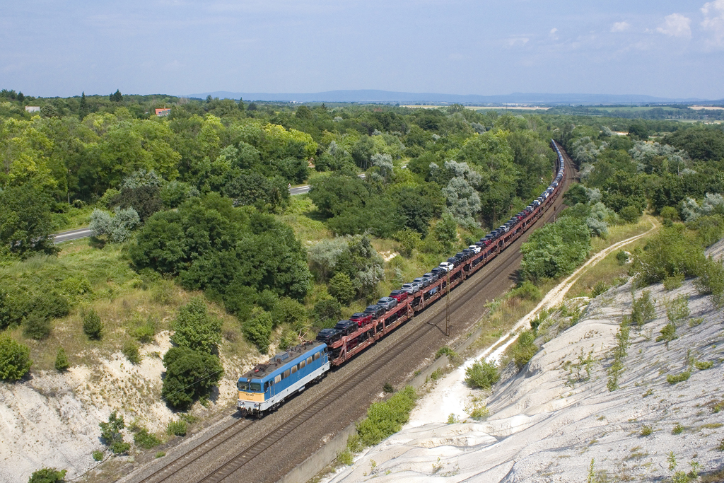 Am 10. Juli 2023 zeigt sich 431 143 mit einem langen Autozug bei Szár in Richtung Westen. 