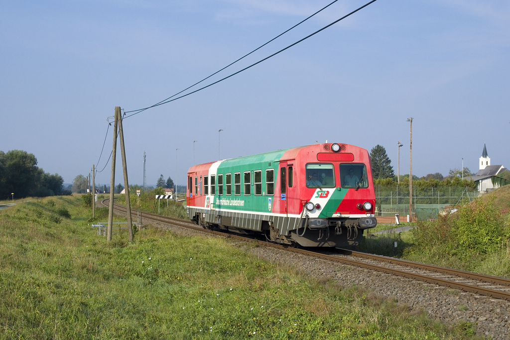 Am 10. September 2016 ist 5047 401 als SLP 98073 von Fehring nach Szentgotthárd unterwegs und konnte vor der Kulisse der Kirche sowie des Tennisplatzes von Mogersdorf (Nagyfalva) festgehalten werden. 