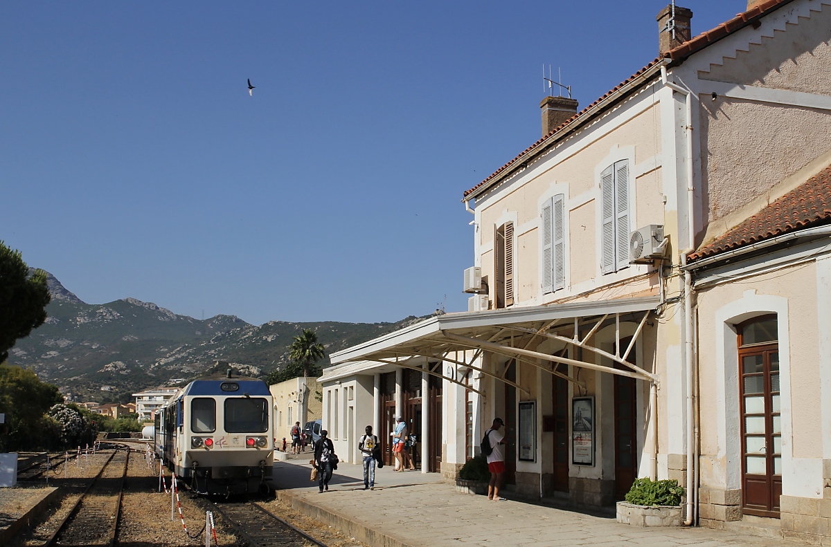 Am 10.06.2014 wartet ein Zug der  Tramway de la Balagne , bestehend aus X 57051 und XR 9701, im gepflegten Bahnhof Calvi auf Fahrgäste in Richtung Ile-Rousse. Mit ihren zahlreichen Zwischenhalte ist diese Bahn die bequemste Möglichkeit, die Badestrände in der Bucht von Calvi zu erreichen.