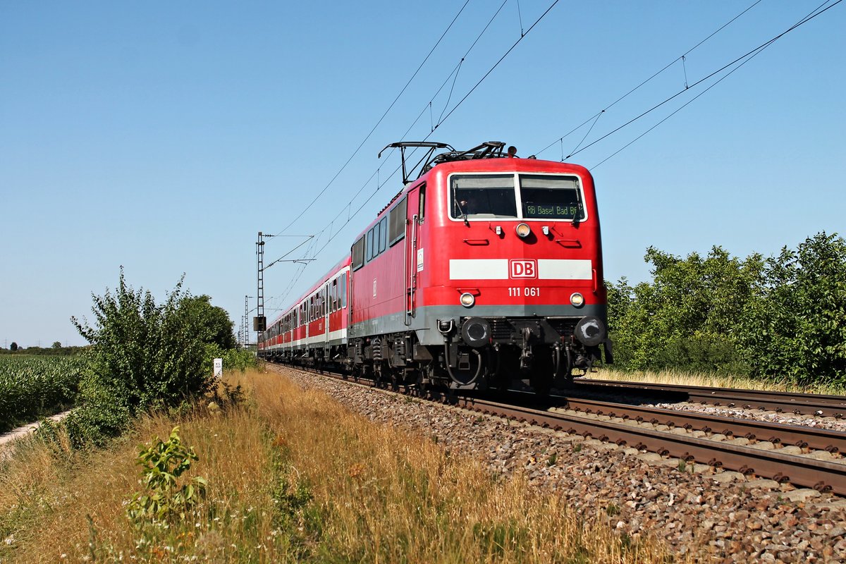 Am 10.07.2015 bespannte die Freiburger 111 061 eine RB (Offenburg - Basel Bad Bf), als sie bei Hügelheim in Kürze in ihren nächsten Zwischenhalt in Müllheim (Baden) einfuhr.