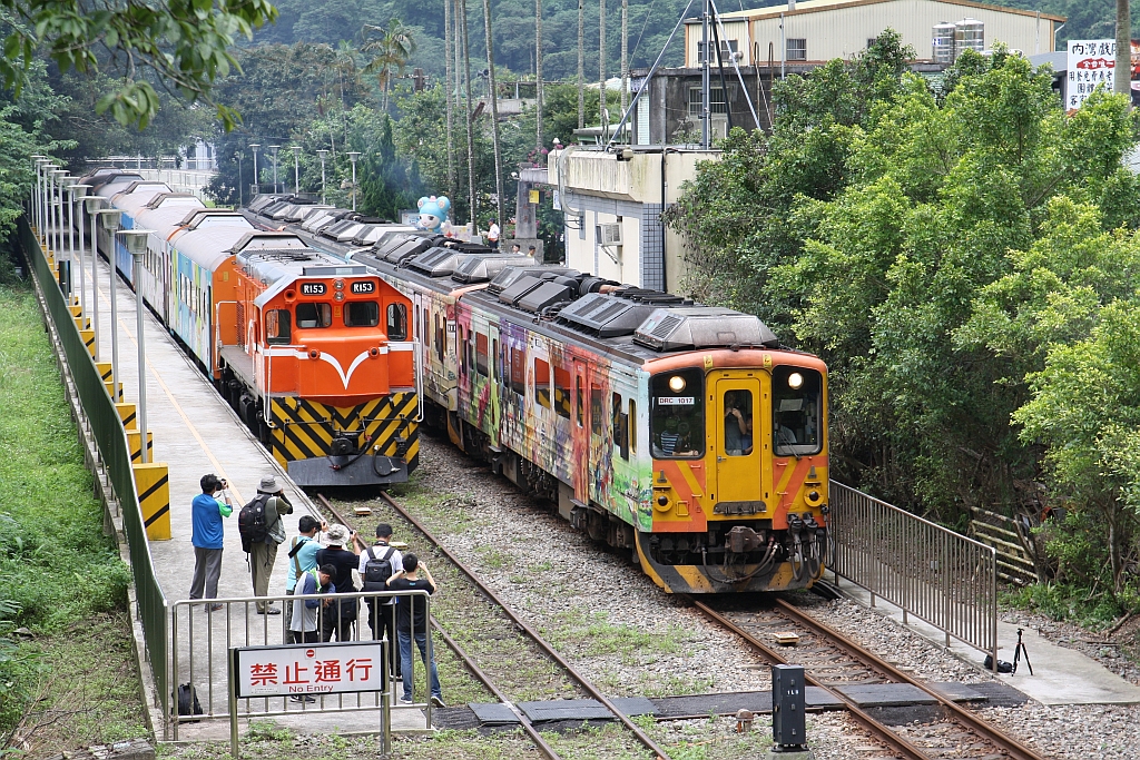 Am 10.Juni 2017 wartet in der Neiwan Station die R153 (Co'Co'-de, GM-EMD, Type G22CU, Bauj. 1973, Fabr.Nr. 712757) mit einem Sonderzug auf die Rückkehr der Passagiere während der DRC1017 als Local Train 1815 nach Zhuzhong Station ausfährt.