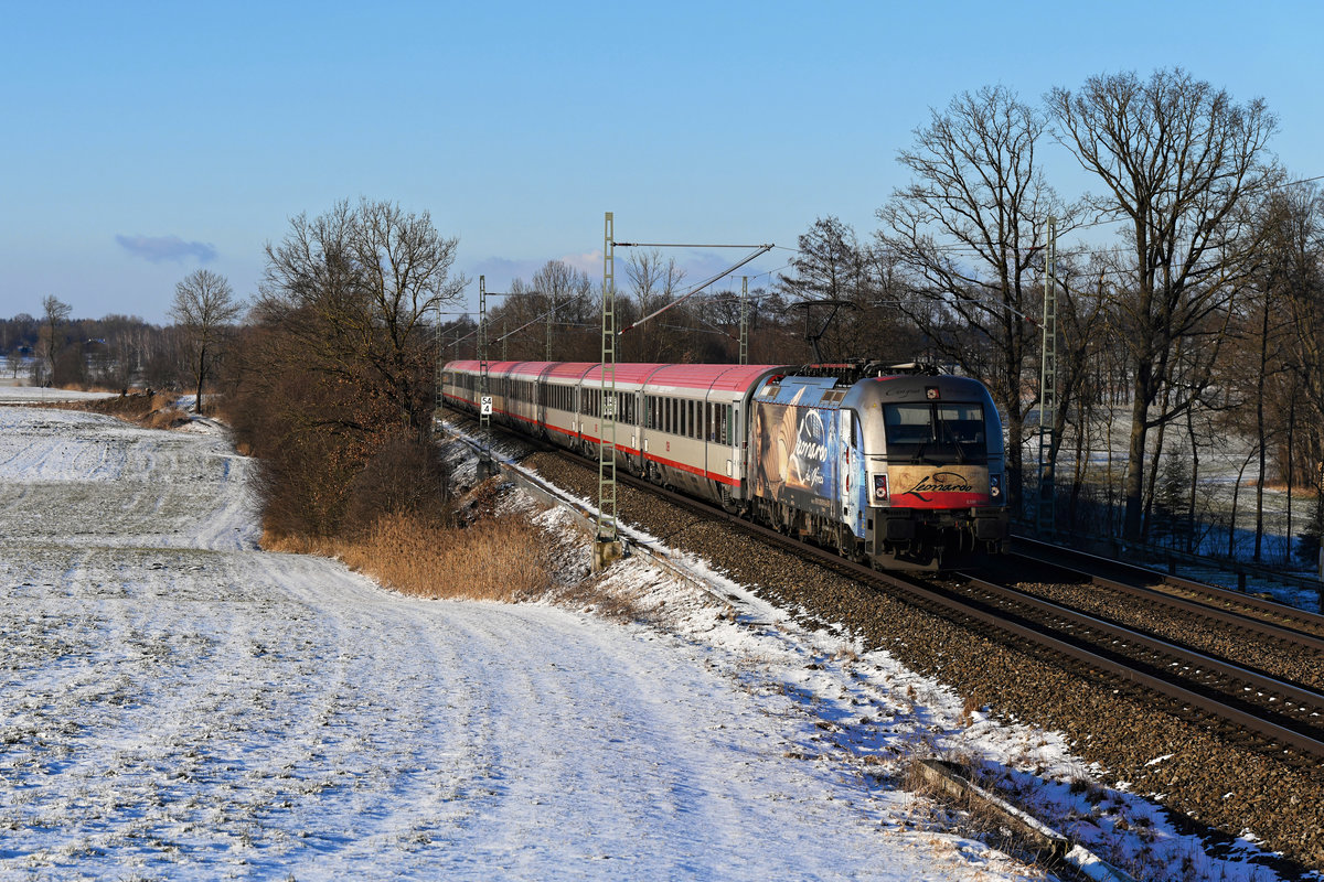 Am 11. Februar 2021 konnte ich die 1216.019 vor dem EC 83 von München Hbf nach Verona Porta Nuova an der ehemaligen Blockstelle Hilperting aufnehmen. Die im Auftrag der Modelleisenbahn GmbH erfolgte äußere Gestaltung des Taurus soll an das Universalgenie Leonardo da Vinci erinnern. 