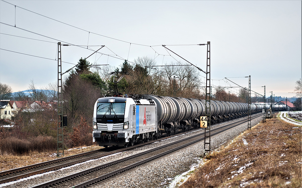 Am 11.12.2017 fährt in Langenisarhofen bei grauem Wetter die 193 811-7 Retrack mit einem Kesselwagenzug vorüber. 