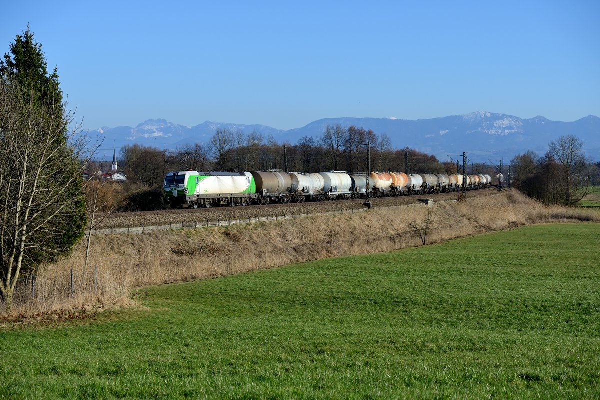 Am 12. März 2017 brachte die SETG 193 240 den Schlammkreidezug DGS 49878 von Frailassing nach Plattling. Bei Rann konnte ich die Leistung aufnehmen. Die gute Fernsicht erlaubte einen klaren Blick auf die Kampenwand. Links im Bild der Kirchturm von Großkarolinenfeld.