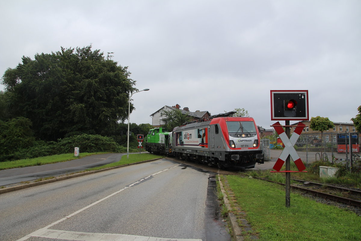 Am 12.8.17 wurde eine Vossloh  DE18  von Moers nach Kiel (Friedrichsort) überführt.
187 014-6 D-CTD der Akiem erledigte dies.
Hier Am Bü Priser Strand.