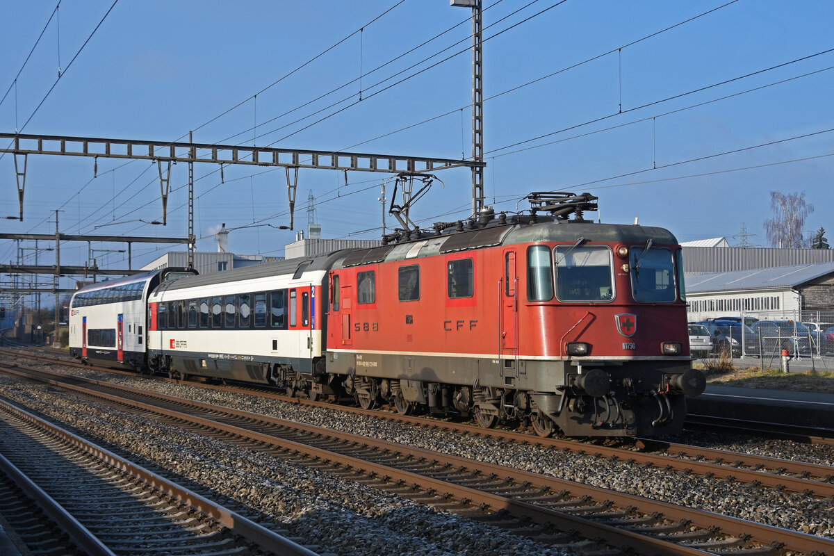 Am 13.01.2022 schleppt die Re 4/4 II 11156 die Personenwagen Bpm 61 85 20-90 301-3 und dem B 50 85 26-94 094-7 durch den Bahnhof Rupperswil.