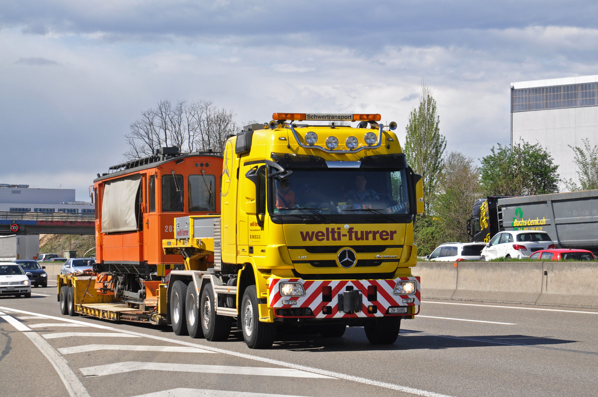 Am 13.04.2018 wird der Schneepflug Xe 2/2 2021, der vom Tramclub Basel übernommen wurde, auf einen Lastwagen verladen und in ein Zwischenlager gefahren. Hier fährt der Lastwagen mit dem Schneepflug Xe 2/2 2021 auf der Autobahn der Raststätte Pratteln vorbei.