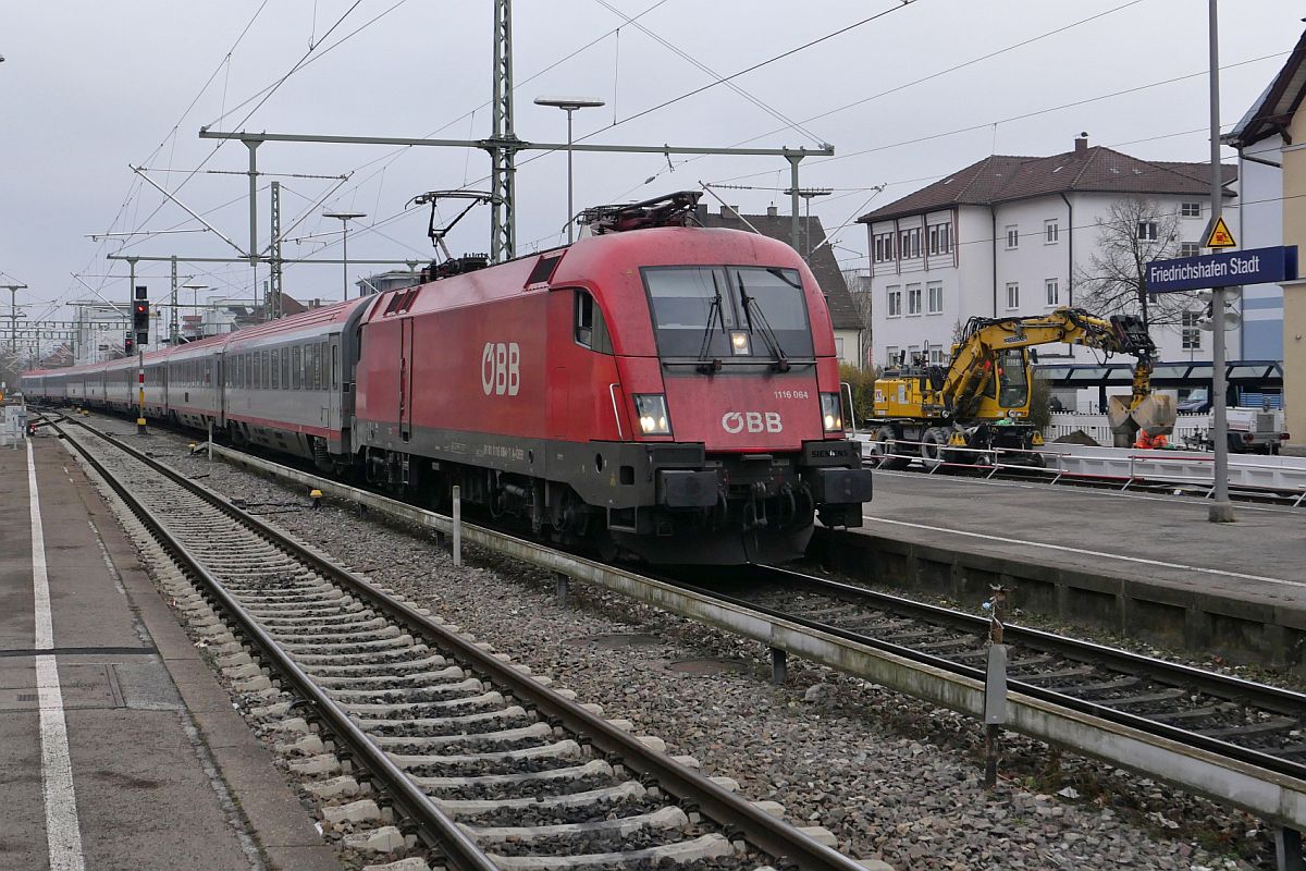 Am 14.12.2021 zieht 1116 064 die Wagen des IC 119  BODENSEE , Dortmund - Innsbruck, in den Stadtbahnhof von Friedrichshafen