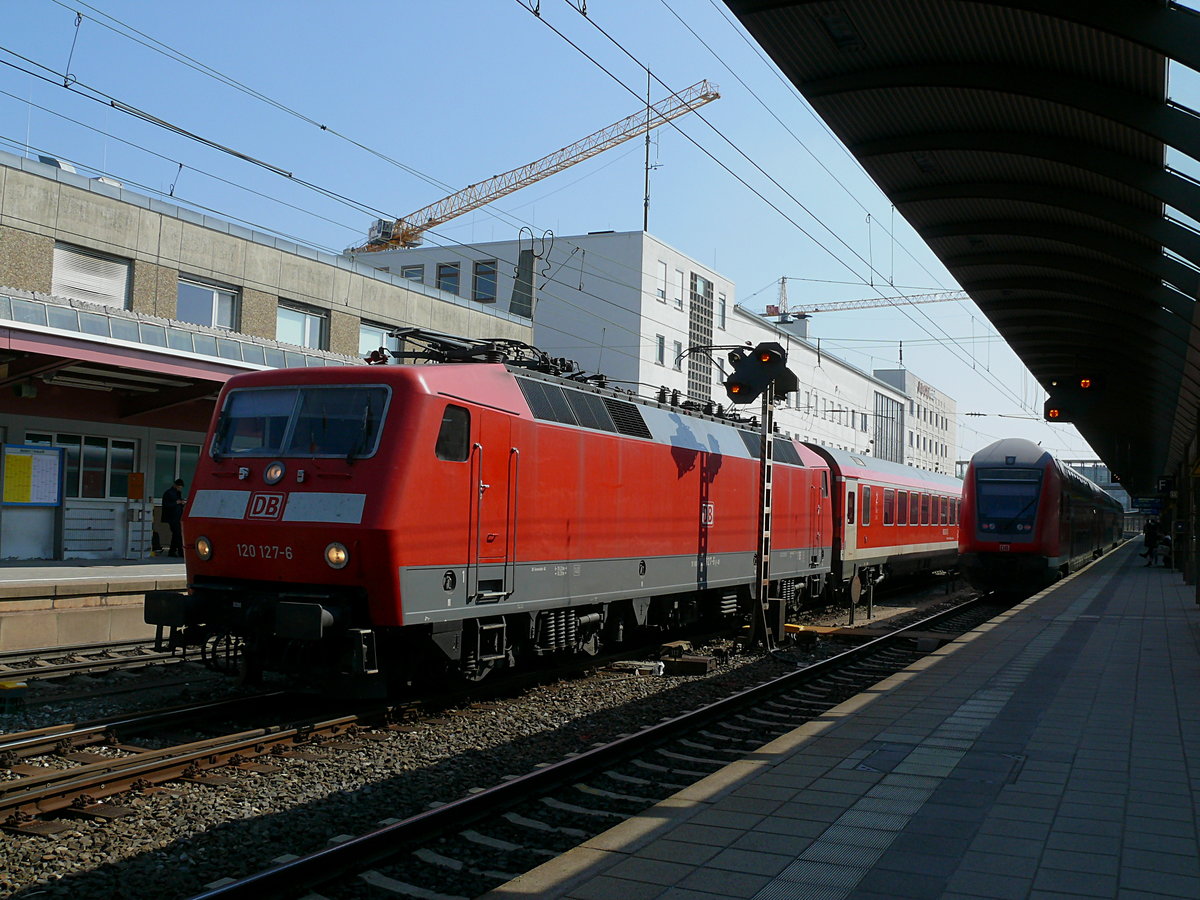 Am 15.04.2019 um 15:14 Uhr fährt 120 127 mit einem PbZ, bestehend aus einem  München-Nürnberg-Express -Steuerwagen, aus dem Ulmer Hauptbahnhof . Zuvor hatte 365 143 zwei Dostos von diesem PbZ abgehangen.