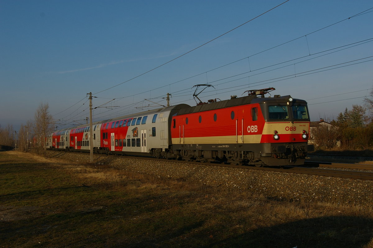 am 16. Dezember 2016 fährt die 1144 092 im letzten Licht bei Sollenau mit dem REX 2239 Richtung Wr. Neustadt.