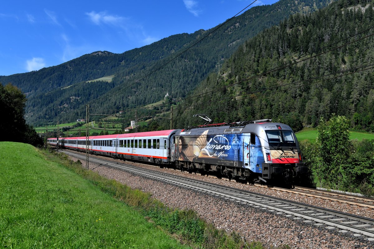 Am 16. September 2019 war der EC 87 nach Venezia Santa Lucia mit der 1216.019 bespannt. Der Taurus trägt aktuell eine Folierung, die an das italenische Universalgenie Leonardo da Vinci erinnern soll. Die Fotostelle bei Mauls / Mules bot sich für eine fahrzeugorientierte Aufnahme an, dankenswerterweise waren Lok und Wagenpark schön sauber. 