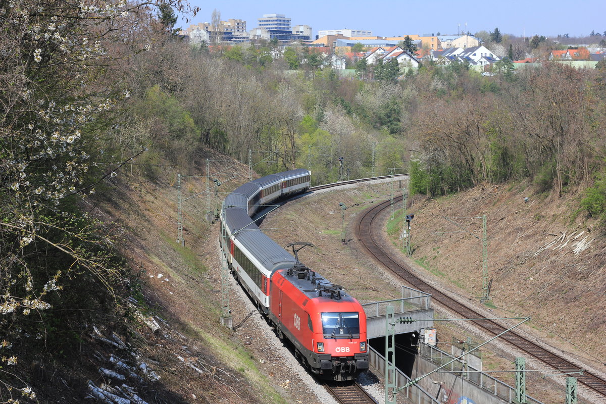 Am 16.04.2019 zieht 1116 137 ihren IC nach Zürich über die Panoramabahn. Die Aufnahme entstand von der sogenannten  Weißen Brücke  nahe der Station Stuttgart-Österfeld. Im Hintergrund befindet sich links die Uni Stuttgart und rechts das Wohngebiet Dachswald. 
