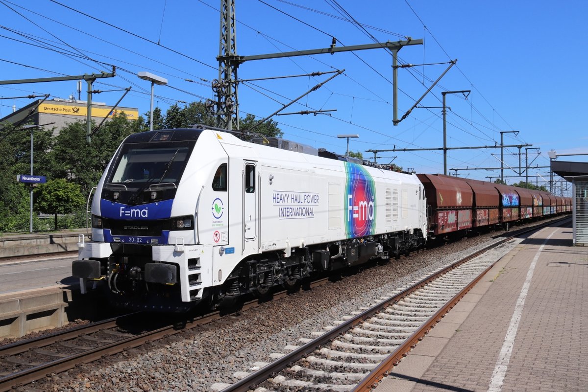 Am 16.06.2020 rangiert HHPI 20-02 (90 80 2159 202-1 D-RCM) unter Einsatz ihres Dieselmotors mit einem Fals-Ganzzug im Bahnhof Neumünster. Augenscheinlich trotz Oberleitung, doch für diese Rangierfahrt drückte die Lok ihrem Zug vom nordwärts führendem Hauptgleis höchstwahrscheinlich in den oberleitungsfreien Bereich der neumünsteraner Abstellanlagen.