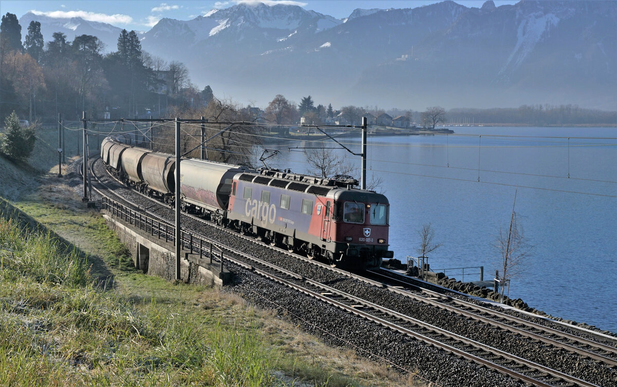 Am 17. Januar 2022 brachte die Re 620 027-3  Luterbach-Attisholz  den Getreidezug  von Domodossola nach Vallorbe.
Die Fotokurve bei Villeneuve am Genfersee passierte der stattliche Zug im Gegenlicht.
Foto: Walter Ruetsch
