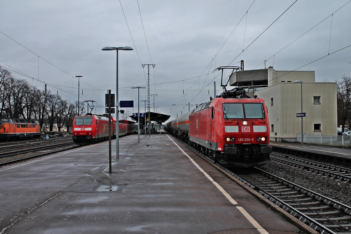 Am 17.01.2015 fuhr die 185 039-5 mit einem gemischten Güterzug durch den Müllheimer Bahnhof, als am Bahnsteig gegenüber die Freiburger 146 109-4  Baden Württemberg erfahren/Lahr (Schwarzw)  mit einer RB (Neuenburg (Baden) - Freiburg (Brsg) Hbf) stand.