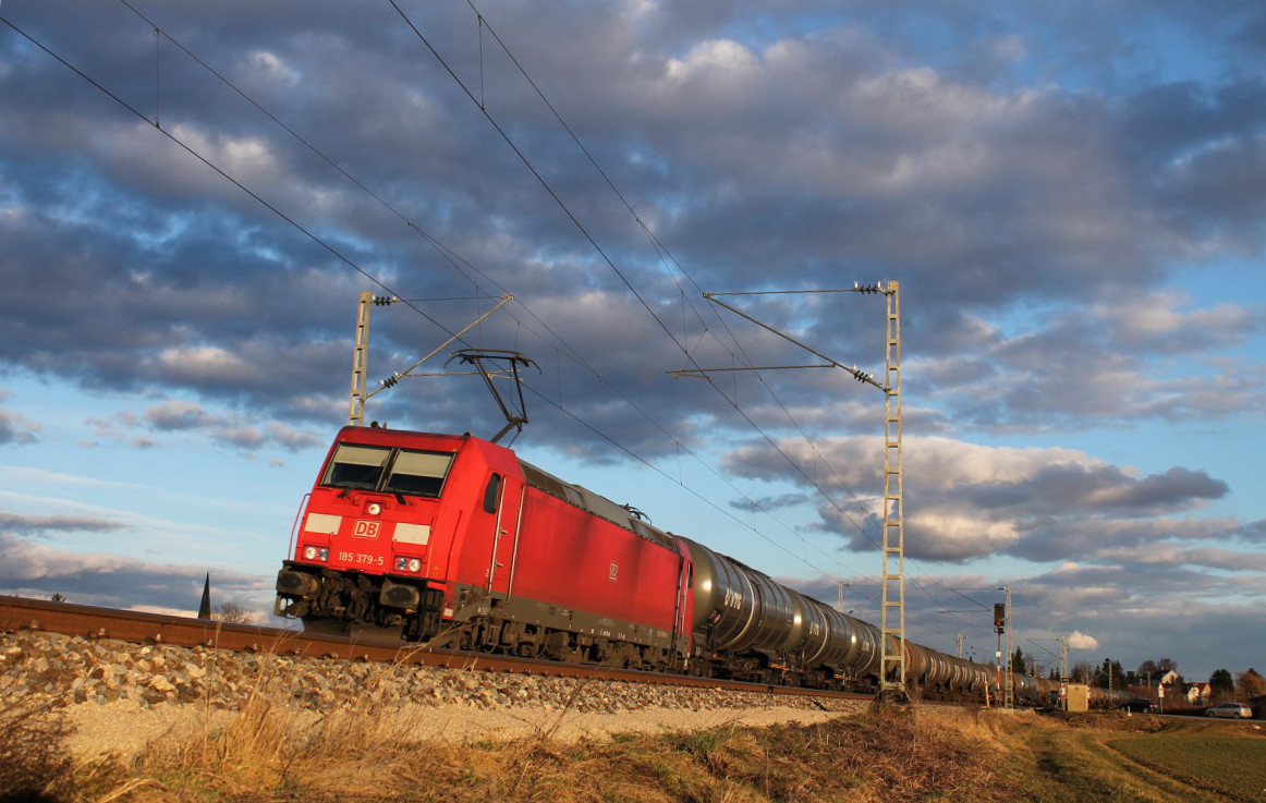 Am 17.02.2014 fährt 185 379 mit ihrem Kesselwagenzug kurz hinter dem Haltepunkt Eitensheim in Richtung Treuchtlingen. Die schon tief stehende Sonne taucht die Szene in bestes Licht.