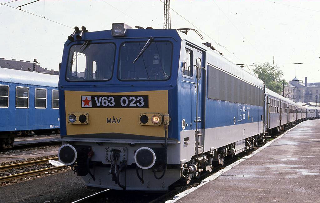 Am 17.4.1989 hat V 63023 der MAV im Bahnhof Nyugati Palyaudvar in Budapest einen langen Regionalzug am Haken.