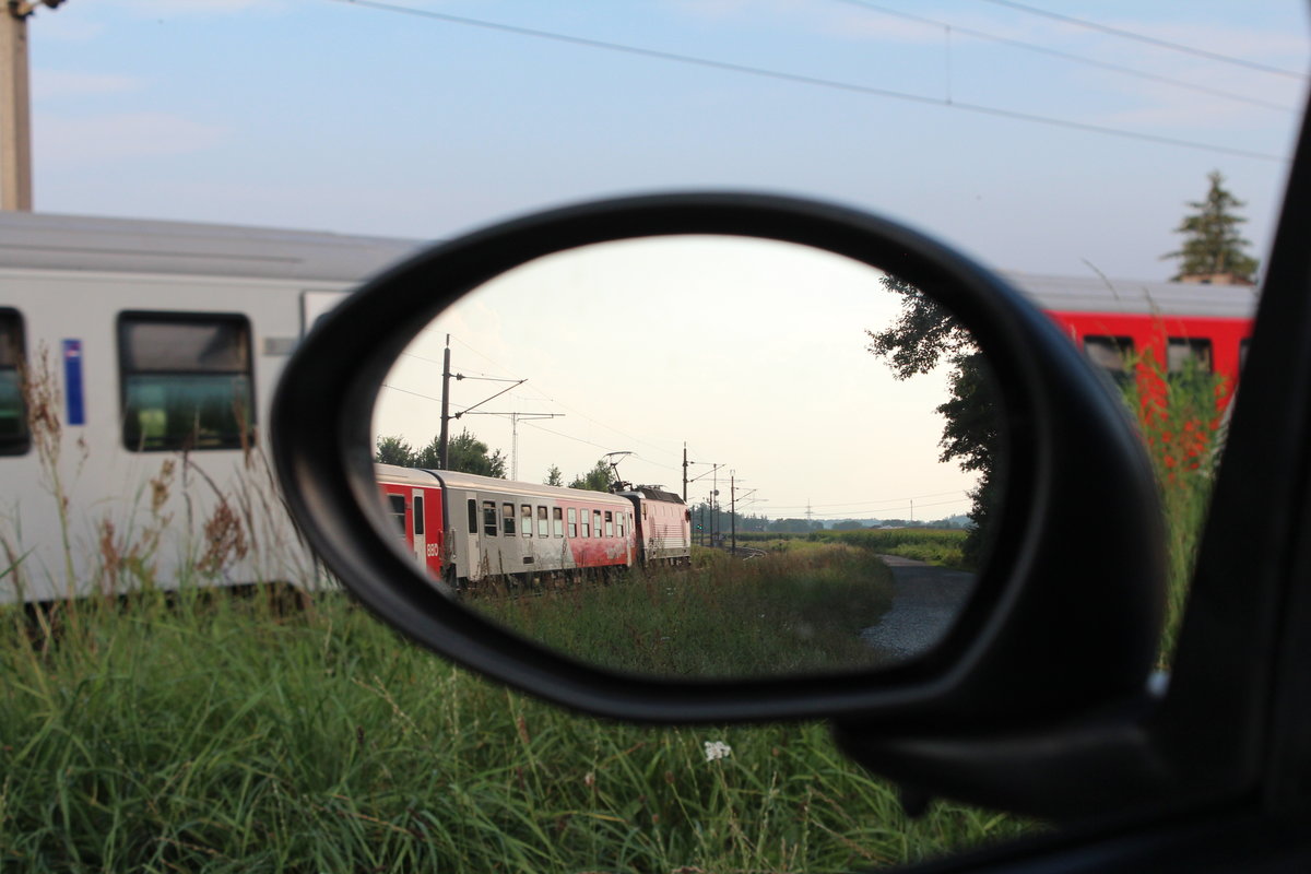 Am 17.7.2015 bringt eine 1144er einen aus  CityShuttle  Wagen gebildeten Regionalzug von Spielfeld-Straß nach Graz Hbf hier kurz vor dem Bahnhof Werndorf in Neudorf bei Wildon.
Kleine Spielerei aus dem Auto hinaus.