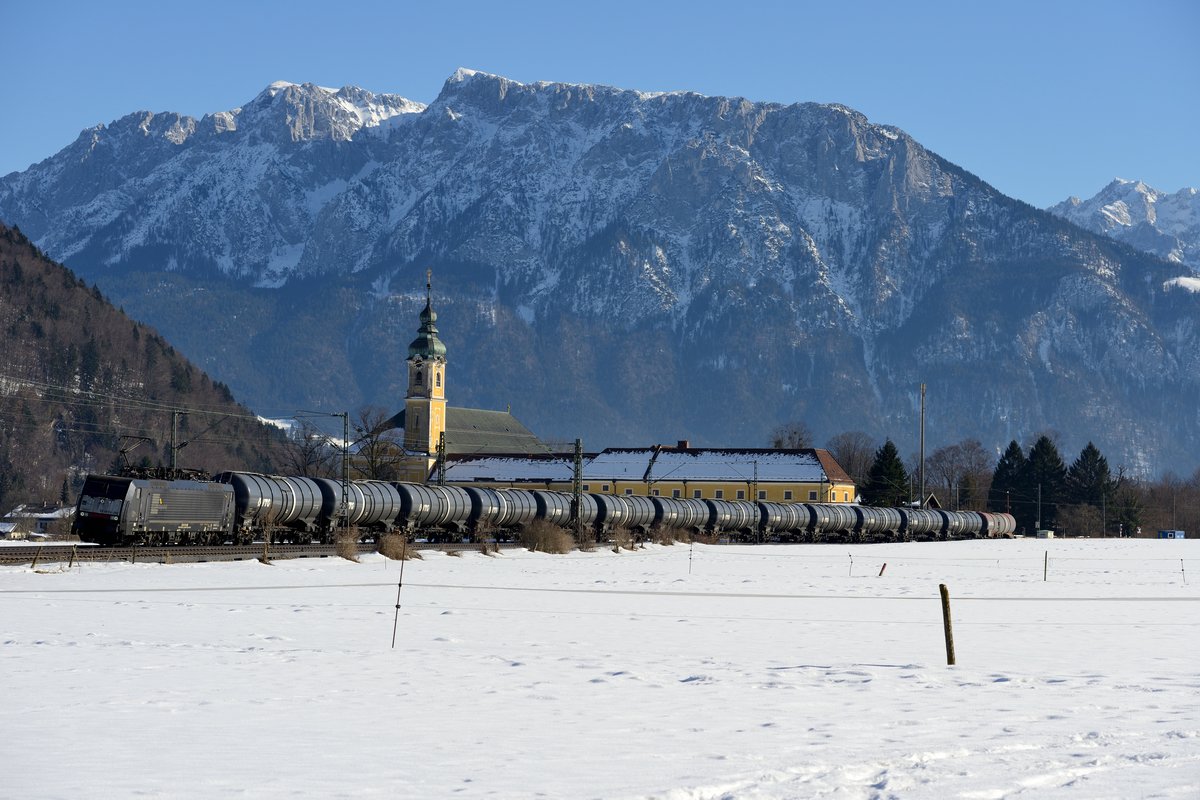 Am 20. Februar 2015 kam nachmittags diese interessante Sonderleistung am Kloster Reisach vorbei: Die an TXLogistik vermietete MRCE Dispolok ES 64 F4 092 beförderte einen Ganzzug, bestehend aus Kesselwagen in Richtung, Rosenheim. Beim diesem Bild bin ich mir etwas unschlüssig: auf der einen Seite hebt sich der schwarze Zug nur bedingt ab, auf der anderen Seite zeigt die Aufnahme eine gewisse Dynamik und der Zug hat die optimale Länge für einen gelungenen Bildaufbau. Ehrliches Feedback erwünscht!