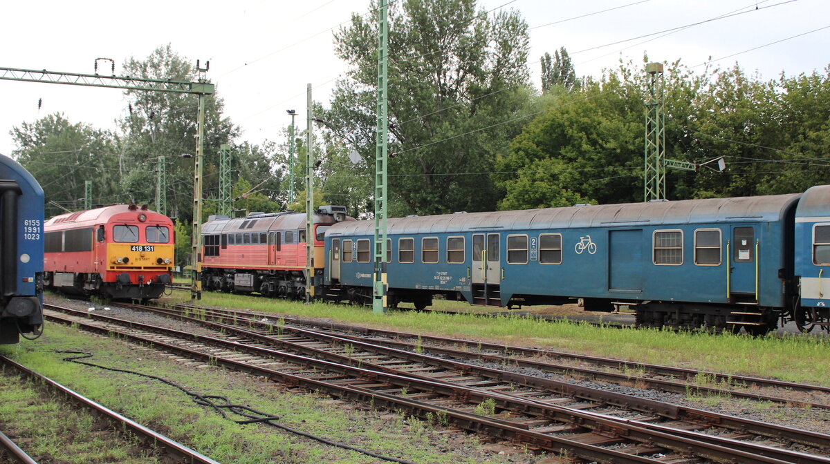 Am 20.07.2024 pausierte der Halbgepckwagen MV H-START 50 55 82-28 106-7 BDbh⁸⁰ mit weiteren Wagen im Bahnhof von Keszthely. Ihm vorgespannt war die MV H-START 628 319, daneben stand die 418 131.  