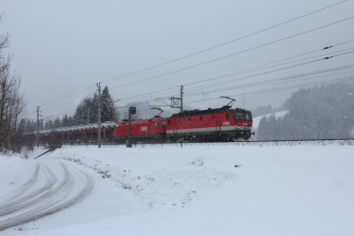 Am 20.2.2018 fährt die 1144 282 und die 1116 124 mit dem verspäteten GAG49415 im dichten Schneefall bei Steinhaus die Semmeringbahn talwärts Richtung Mürzzuschlag.