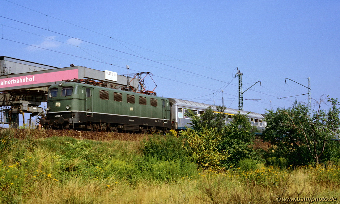 Am 21. August 1987 rollt 141 110-7 mit einen Nahverkehrszug nach Erlangen durch das Nürnberger Stadtgebiet in der Nähe von Neusündersbühl.