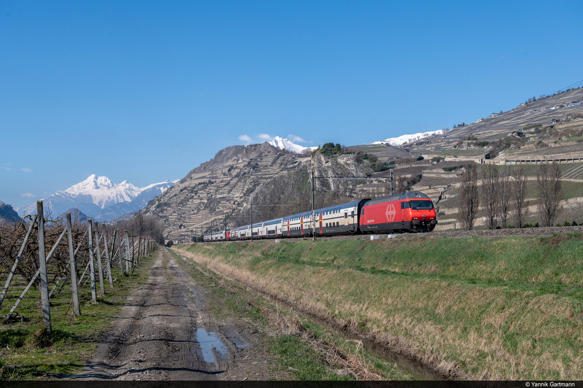 Am 21.03.2021 sind SBB Re 460 040-9 und Re 460 103-5 mit zwei IC2000 Kompositionen als IR90 30809 von Genf Flughafen nach Brig unterwegs und konnten hier vor Saint-Léonard aufgenommen werden.
