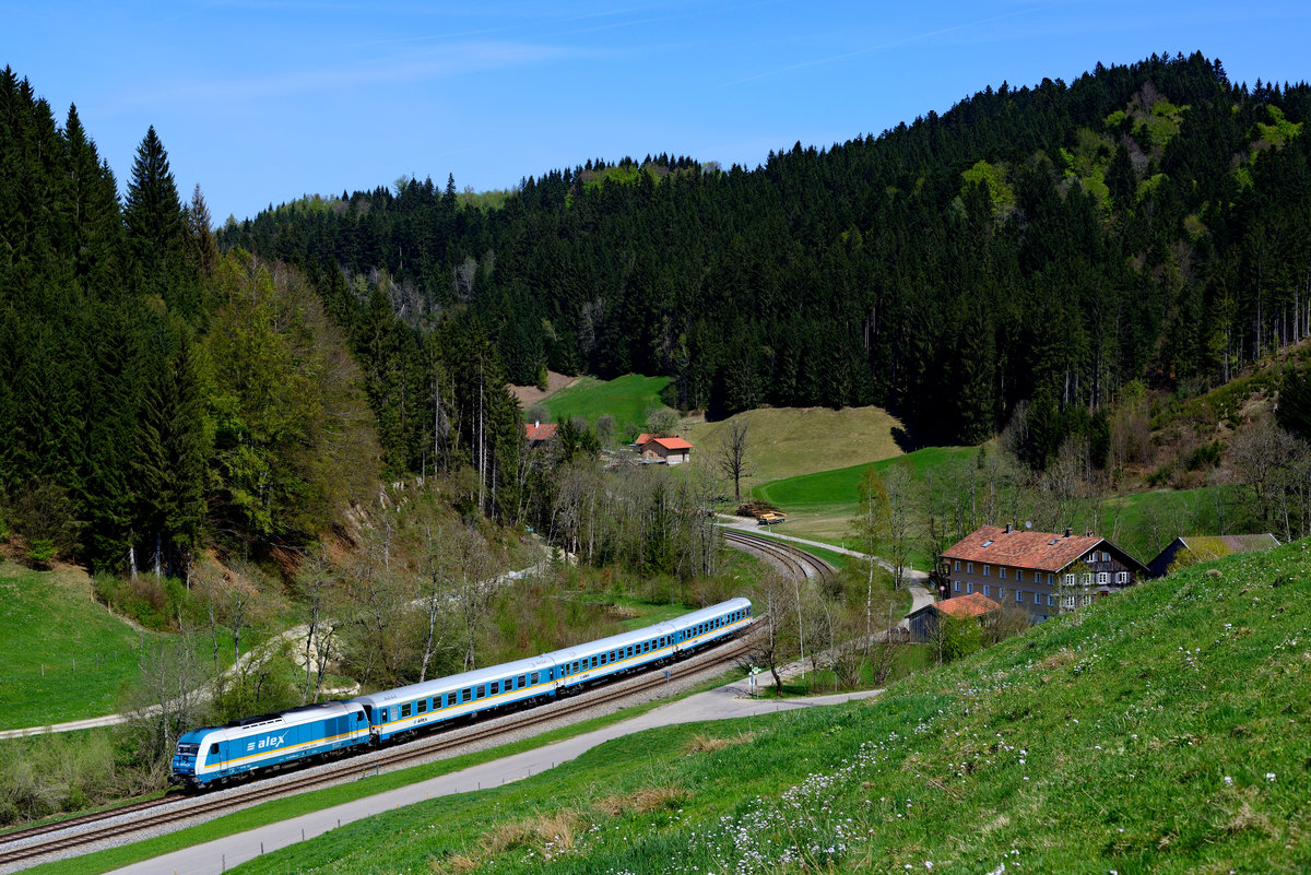 Am 22. April 2018 brachte die 223 066 den ALX 84139 von Lindau nach München HBF. Bei Mutten passierte der Zug ein für das Oberallgäu typisches Gehöft.
