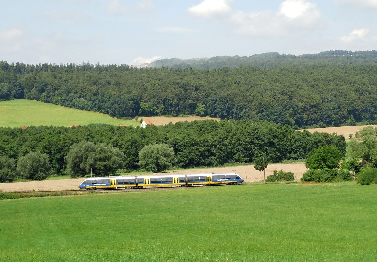 Am 22.07.2016 fährt ein Triebwagen der NordWestBahn am Fotografen entlnag auf seinem Weg von Göttingen nach Adelebsen(Bodenwerder).
Genau oberhalb des Zuges kann man die Abbaufläche des Basaltbruches Bramburg erkennen und seine Ausmaße erahnen.
VT 643 304 .