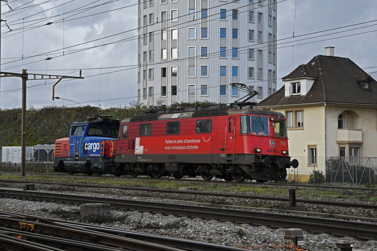 Am 22.12.2022 schleppt die Re 420 243-8 die Eem 923 030-1 durch den Bahnhof Pratteln.